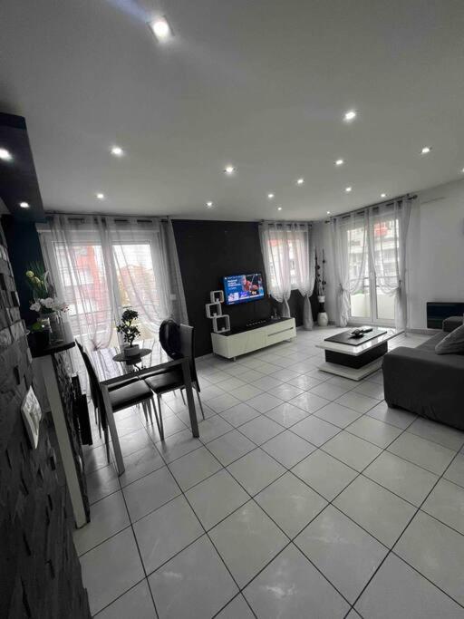 un salon avec un canapé et une table dans l'établissement Très bel appartement entre Paris et Disneyland, à Lognes