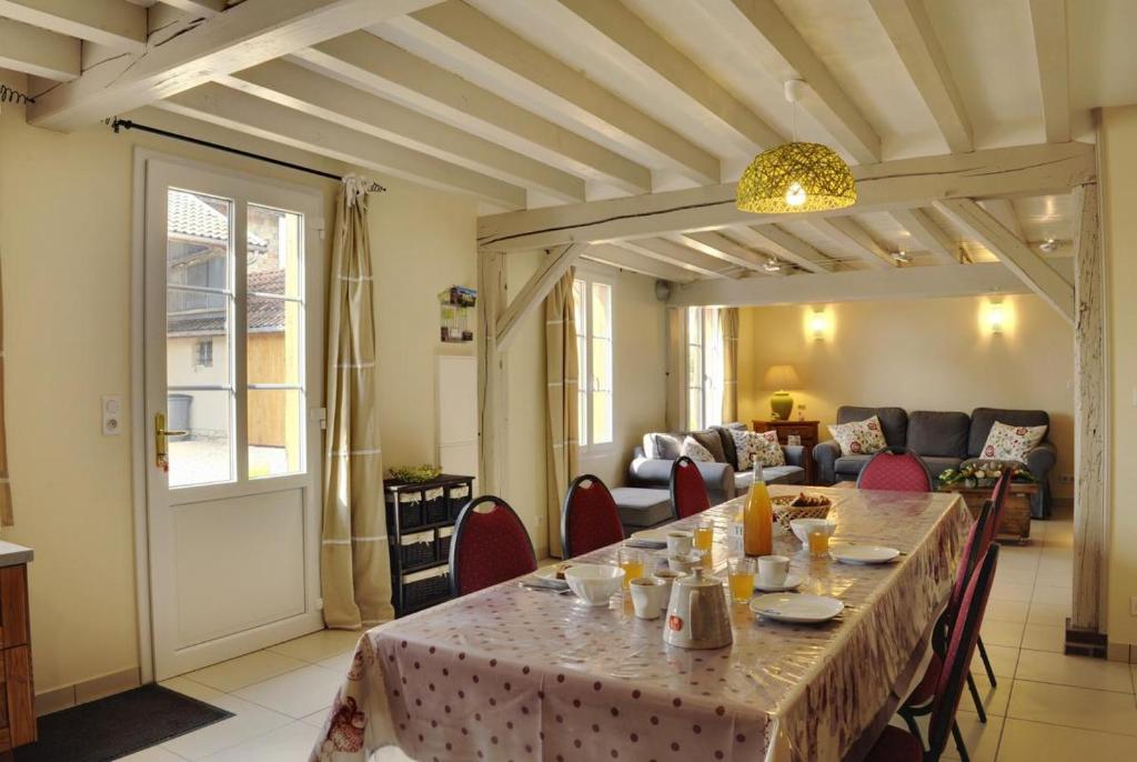 ein Esszimmer mit Tisch und Couch in der Unterkunft Le pre des marguerites in Rosnay-lʼHôpital