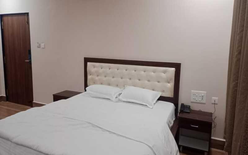 S Conventions and TSR Grand في Vizianagaram: غرفة نوم بسرير ابيض كبير مع وسادتين