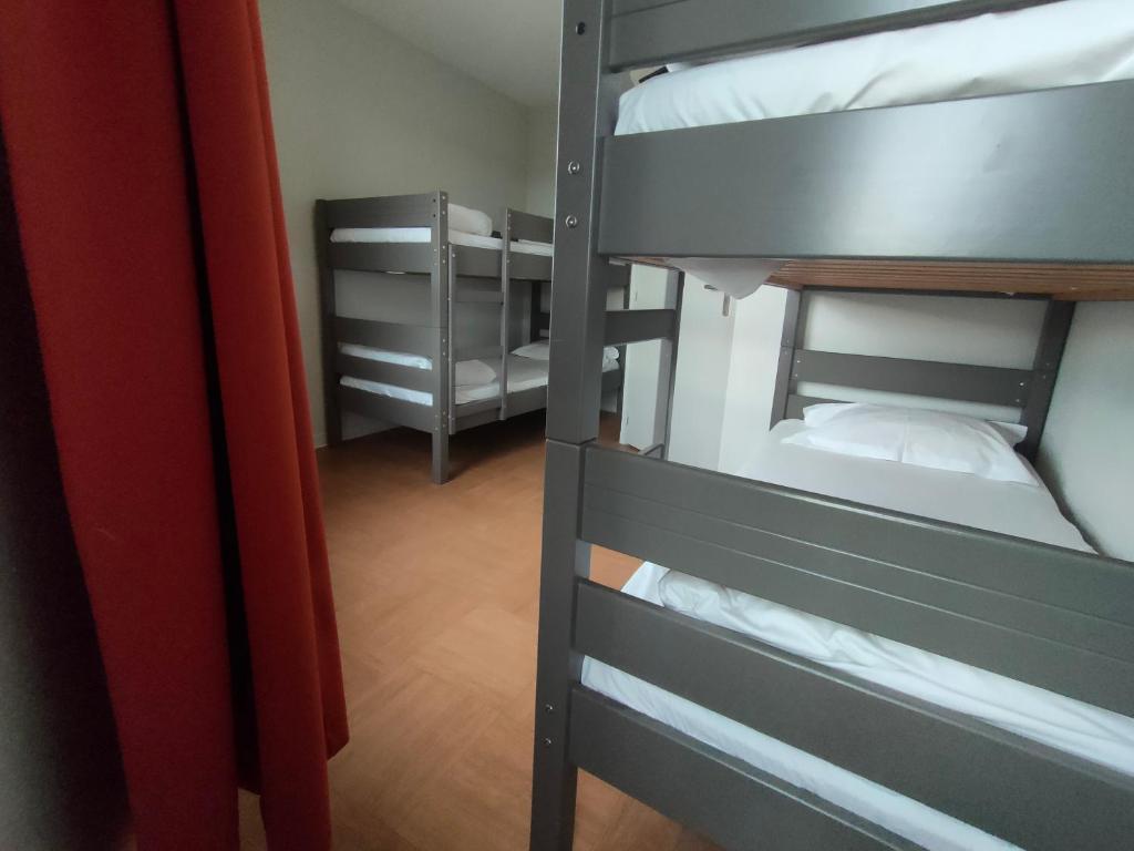 two bunk beds in a small room with a red curtain at ApartHotel Sainte-Marthe in Avignon