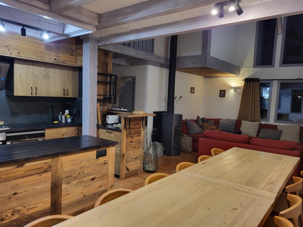 uma cozinha e sala de estar com uma mesa de madeira em Chalet Courchevel La Tania - 14 personnes - 7 chambres 7 salles de bains - 40 m des pistes em Courchevel