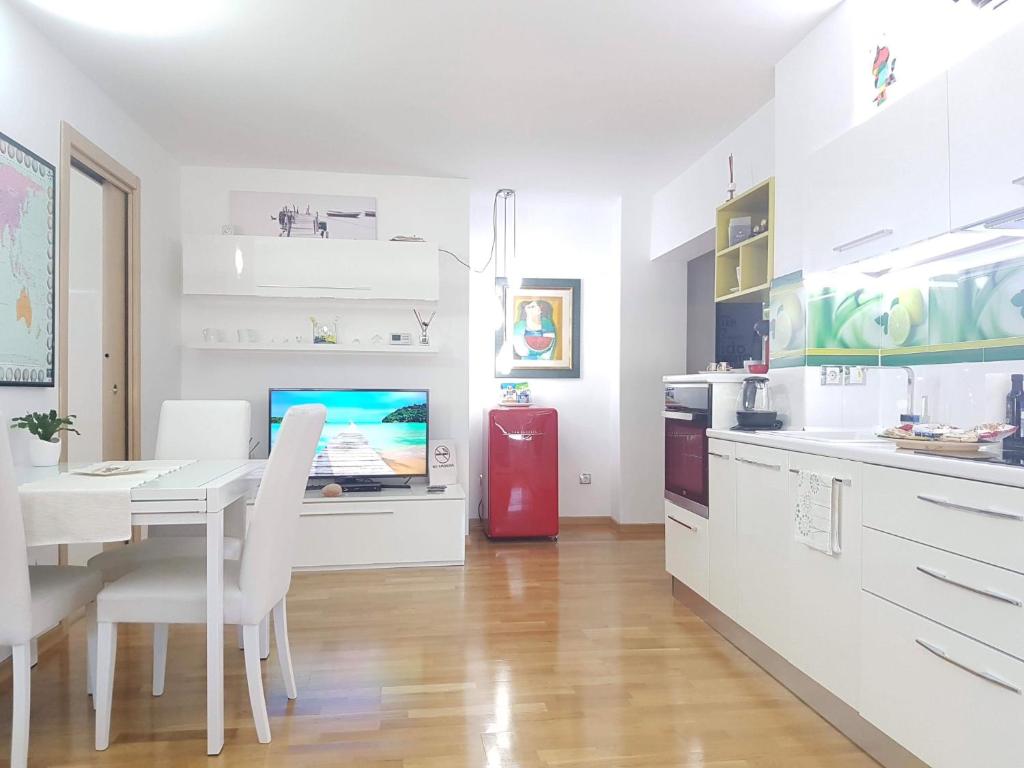 uma cozinha branca com uma mesa e um frigorífico vermelho em White Dream Suites em Iaşi