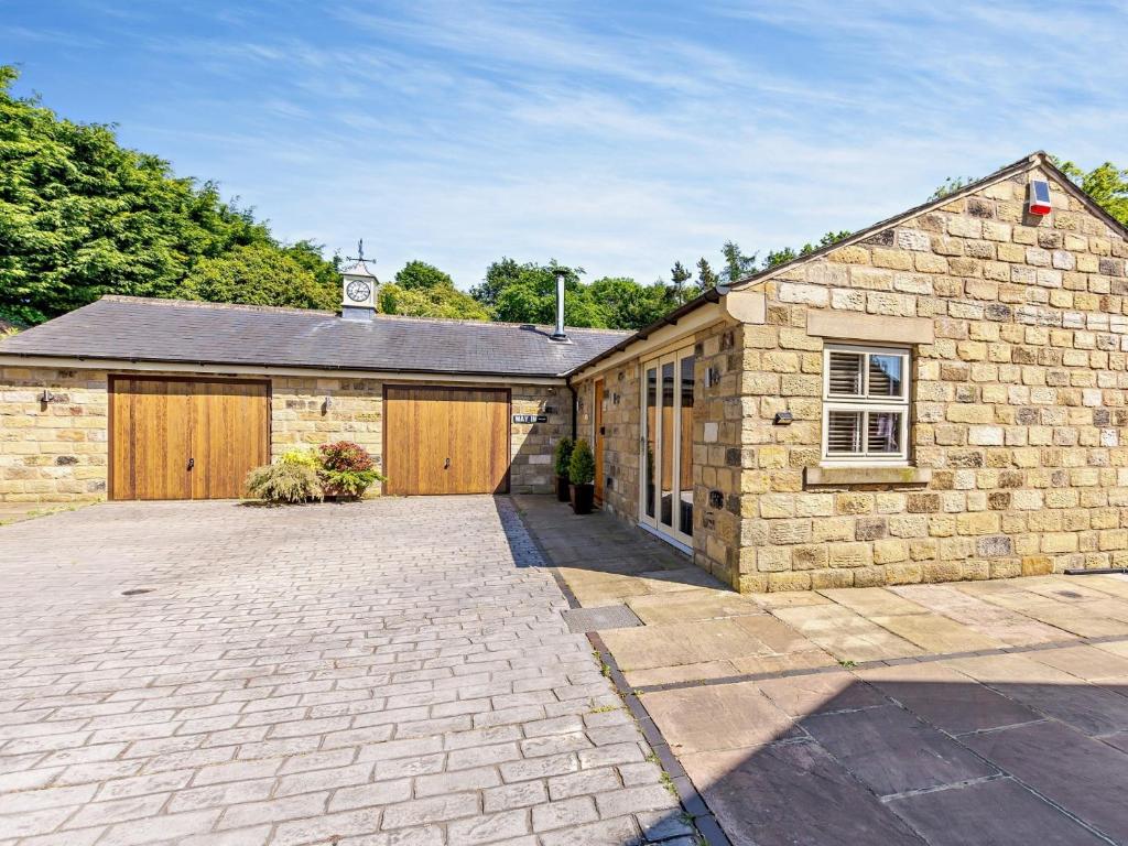 a stone building with a garage and a clock tower at 2 Bed in Nidderdale G0156 in Hampsthwaite