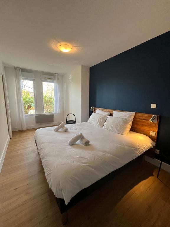 - une chambre avec un grand lit et un mur bleu dans l'établissement Les appartements du Clos de la Chartreuse By Ateya, à Aix-en-Provence