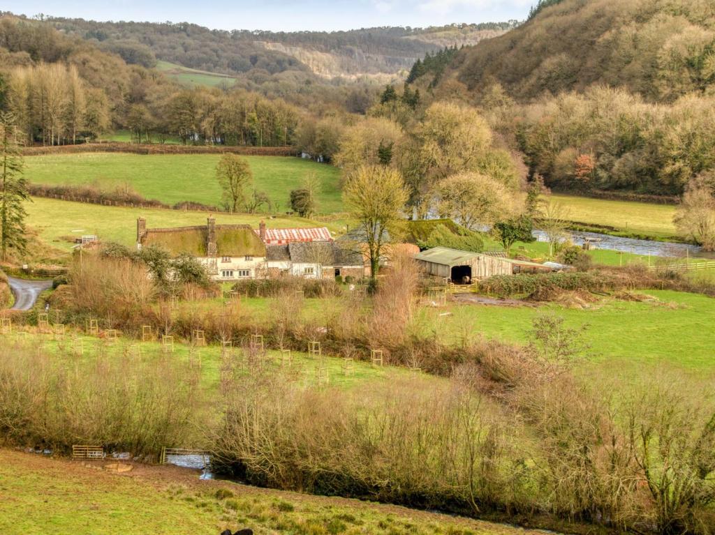 a farm in a field with a barn and a river at 2 Bed in Tiverton 77442 in Washfield