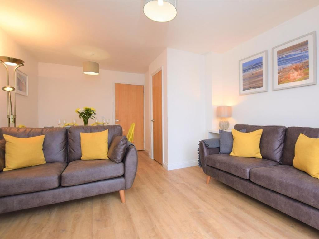 een woonkamer met 2 banken en gele kussens bij 3 Bed in Westward Ho 74354 in Westward Ho