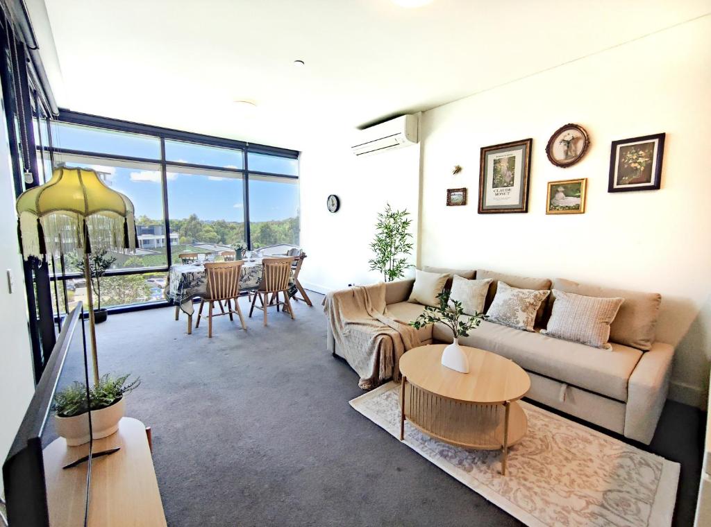 uma sala de estar com um sofá e uma mesa em French Country Style in Olympic Park em Sydney