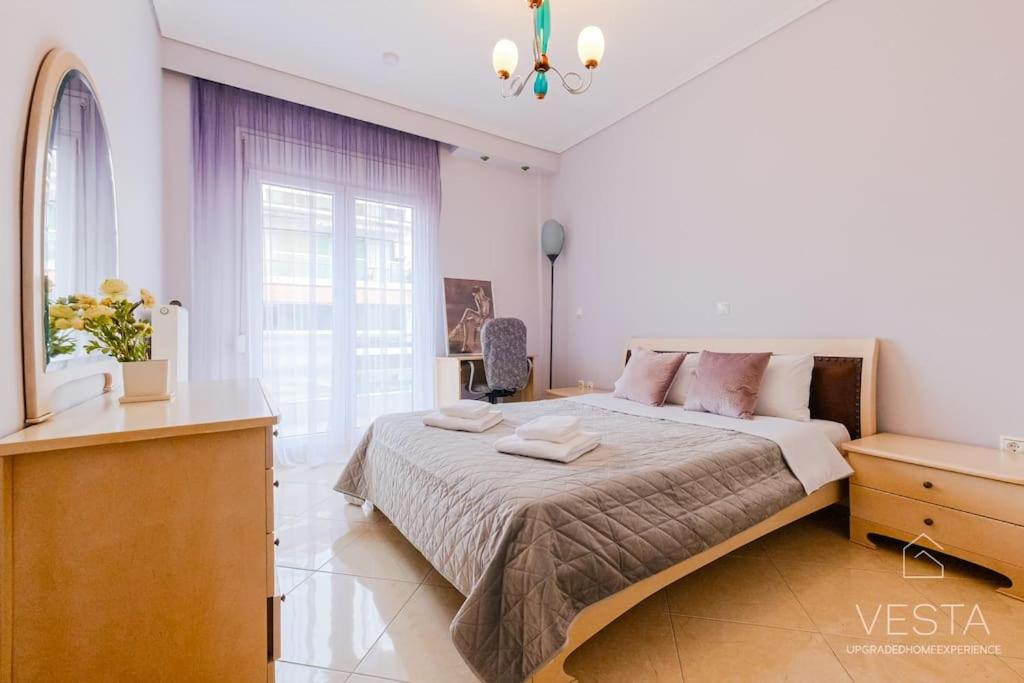 een slaapkamer met een groot bed en een raam bij Lavender 2bdrm Apartment, Vesta Philoxenia in Thessaloniki