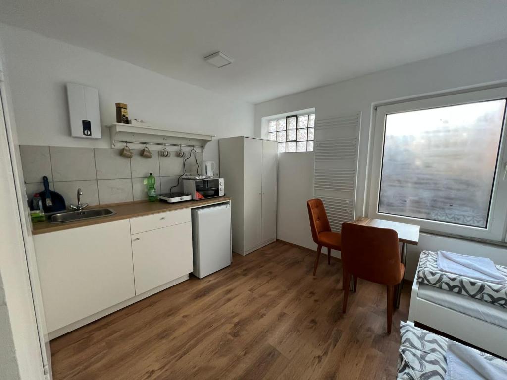 a kitchen with white cabinets and a table and a window at City Flats Dortmund in Dortmund