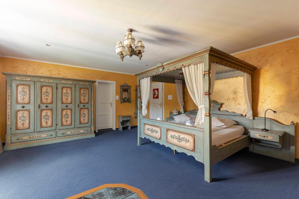 a bedroom with two canopy beds and a chandelier at Hotel Burger Veniše in Rečica ob Savinji