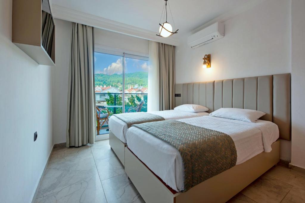 a bedroom with two beds and a large window at Golden Orange Apart in Marmaris