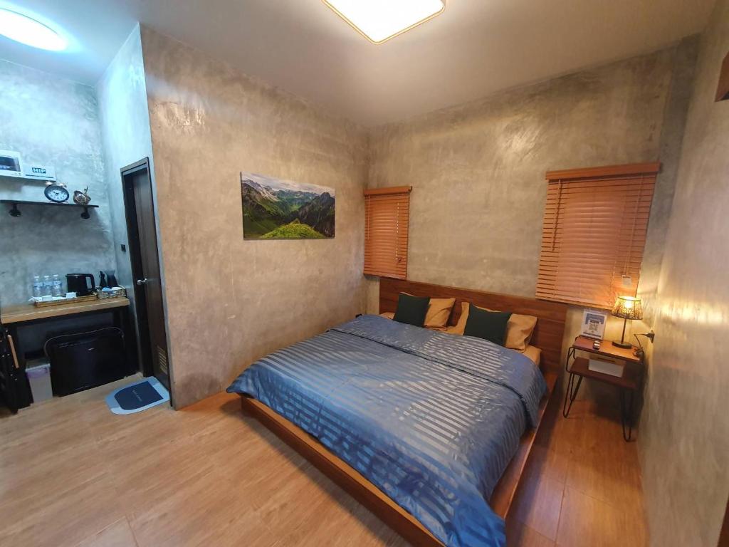 - une chambre avec un lit et un bureau dans l'établissement Kedthawa Homestay เฮือนภูผา, à Ban Cho Lae