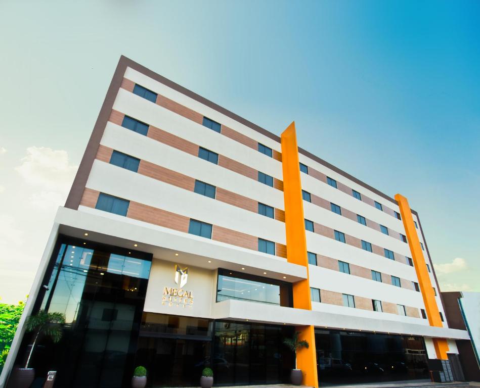 Megal Suites Hotel في سيوداد ديل إستي: مبنى امامه اعمدة برتقالية