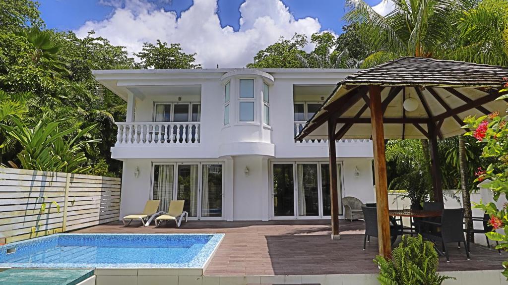 a villa with a swimming pool and a house at Chateau Elysium - Two bedroom villa 1 in Beau Vallon