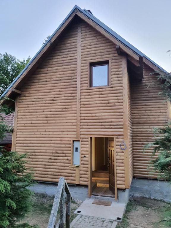 a wooden house with a door in front of it at Dzemper Cottage House in Mitrovac