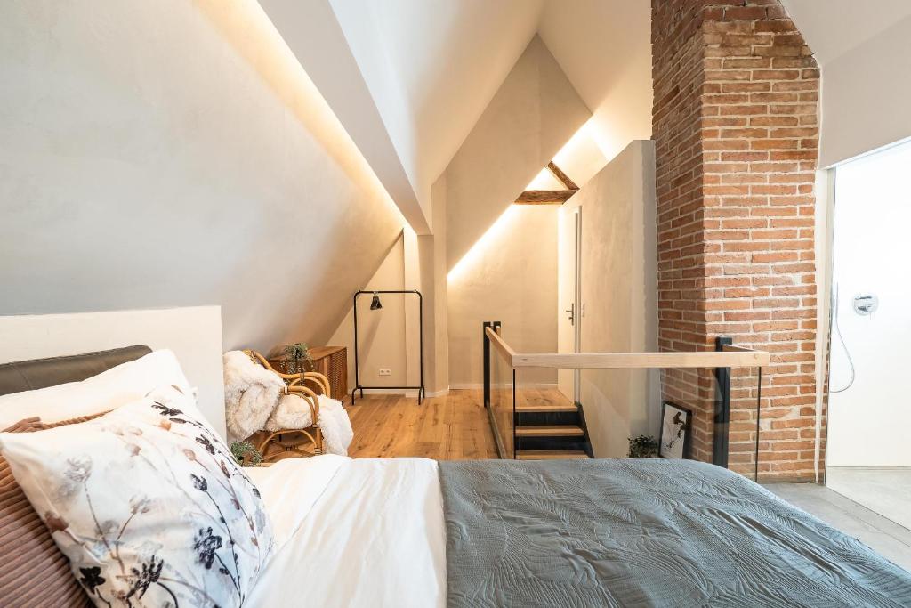 a bedroom with a bed and a brick wall at Luxury Penthouse on the Lake in Überlingen