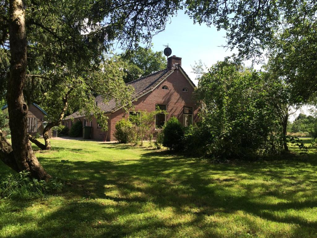 an old brick house with a green yard at Apartment Zus en Zo in Uffelte