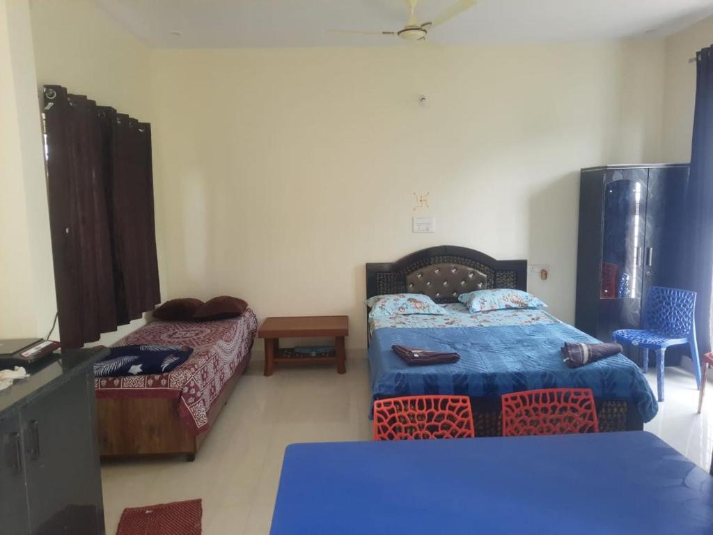a room with two beds and a table in a room at Nandi Skandagiri Guest House in Nandi