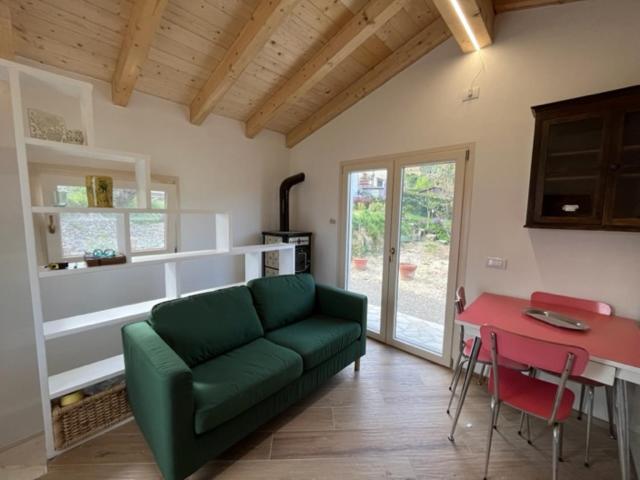 ein Wohnzimmer mit einem grünen Sofa und einem roten Tisch in der Unterkunft La Casina a Treggiaia in Treggiaia