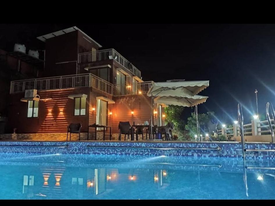 una casa con piscina por la noche en Skyview Villa Udaipur, en Udaipur