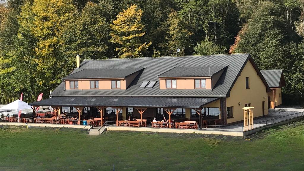 een huis met een zwart dak met tafels en stoelen bij Ski & Wake Resort Těrlicko in Dolní Těrlicko