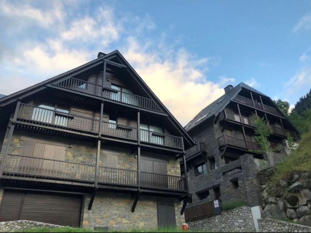 特雷多斯的住宿－Casa Valle de Arán - Baqueira，旁边带阳台的建筑