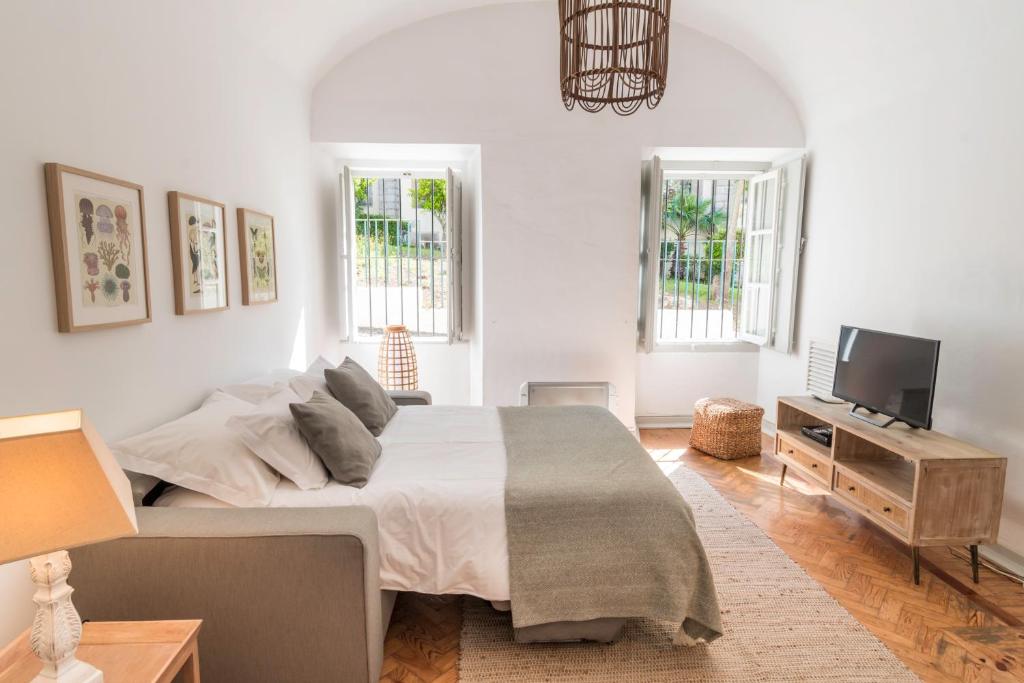 1 dormitorio con 1 cama grande y TV en Convent's House, en Évora
