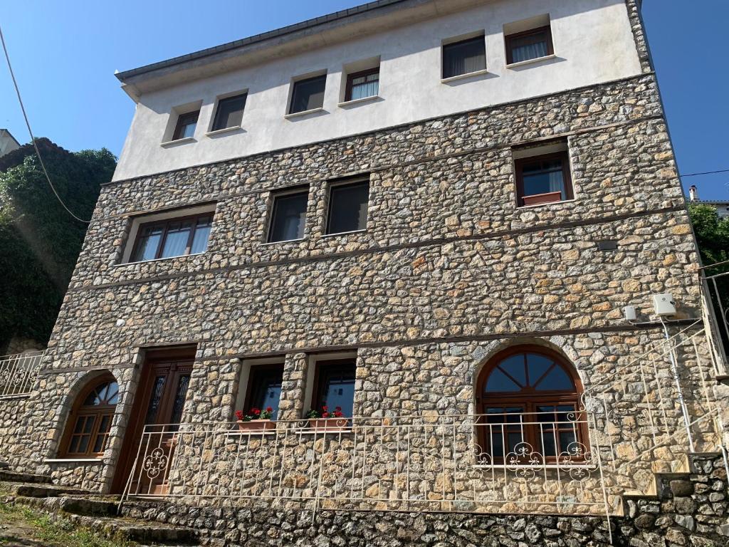 a stone building with windows on the side of it at ΟΙΚΙΑ ΑΠΟΖΑΡΙ ΜΕΓΑΛΗ ΠΕΡΣΑ in Kastoria