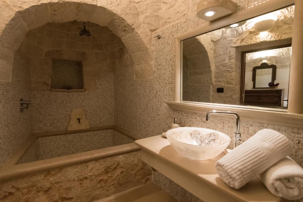 une salle de bains avec lavabo et baignoire dans l'établissement Trulli Angela, à Locorotondo