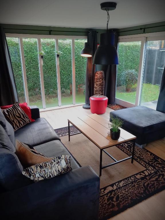 a living room with a couch and a coffee table at Veluwepark Reewold #Chalet Buizerd# tussen het bosrijke Putten en Garderen in Putten