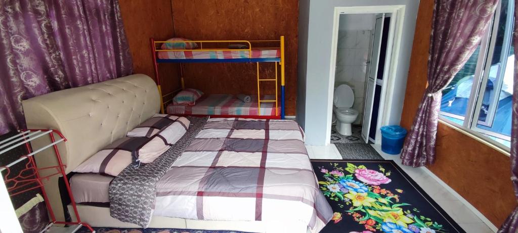 um pequeno quarto com uma cama num quarto em Teniat Village em Rantau Panjang