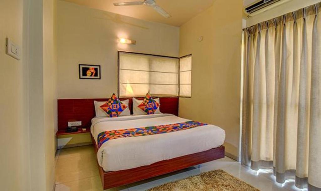 a bedroom with a large bed and a window at FabHotel Sky Vista Inn in Pune