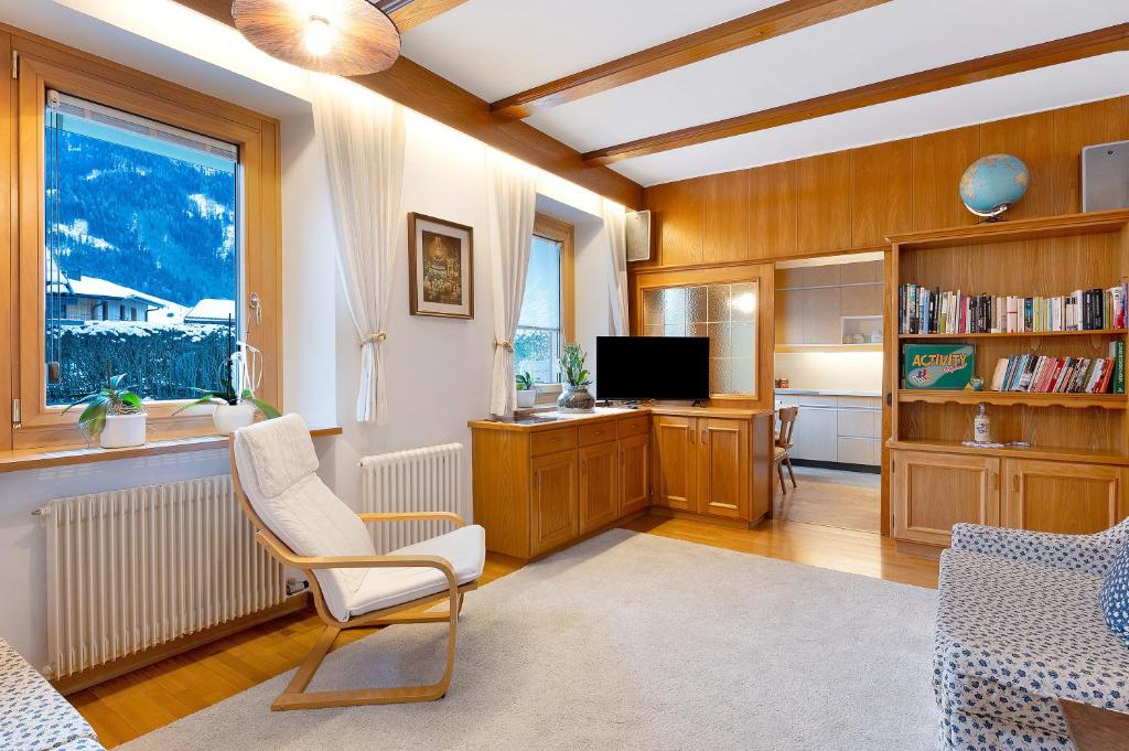 a living room with a chair and a television at Appartamento Cesa Wanker in Ortisei