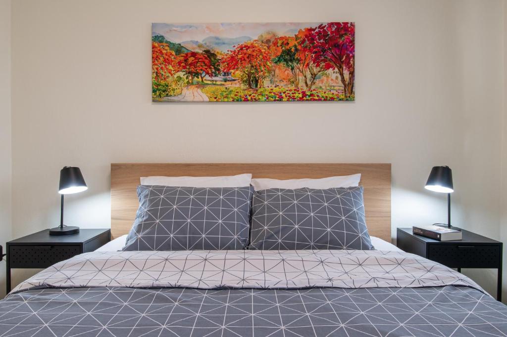 Bright home SKG في سلانيك: غرفة نوم بسرير مع مصباحين ولوحة