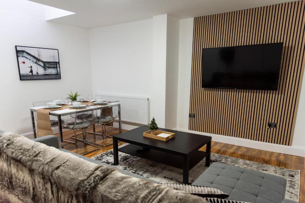 a living room with a couch and a table at Stylish 3 bedroom flat, free parking in London