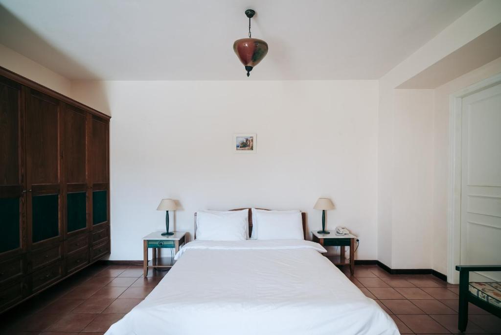 a bedroom with a white bed and two tables at Century Resort in Acharavi