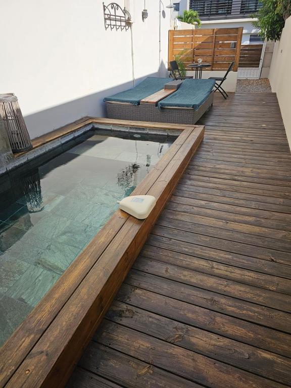 Bazén v ubytování Tiny Badamier Blanc appartement 4 étoiles 2 à 4 personnes piscinelle chauffée nebo v jeho okolí