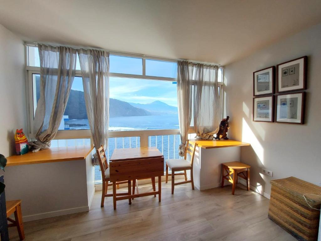 a room with a large window with a table and chairs at Apartamento PRIMERA LINEA DE MAR in Tacoronte