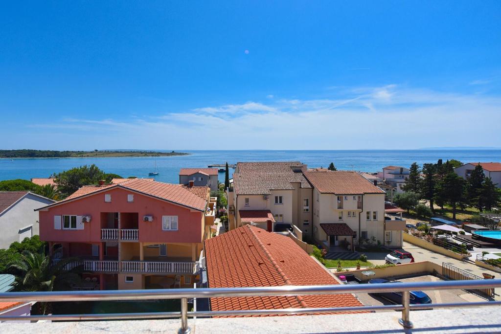 a view of a town with houses and the ocean at Apartments Bella Sky V in Novalja