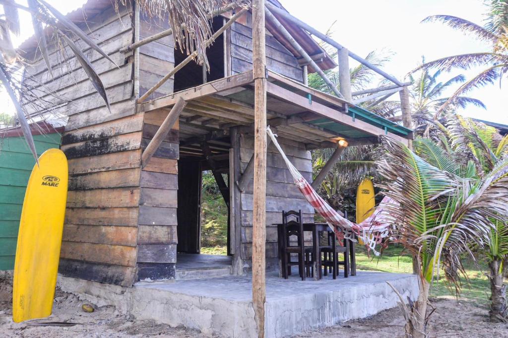a small wooden house with chairs and a porch at Céu da Vida Eco Cabana in Pipa