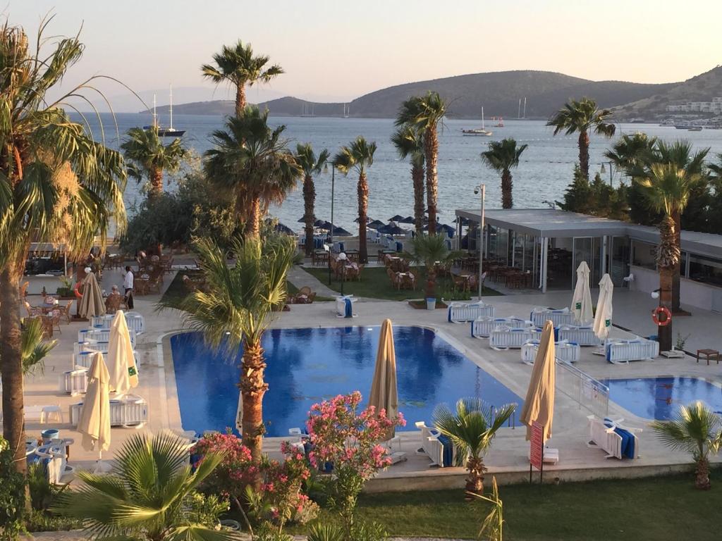 uma vista para um resort com uma piscina e palmeiras em Nagi Beach Hotel em Gümbet