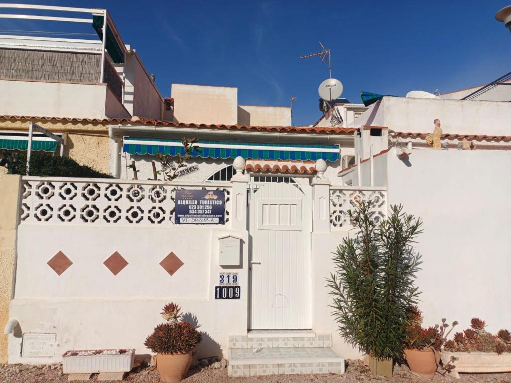 a white fence with a gate and a door at Charming Bungalow in Torrevieja Near La Mata Natural Park in La Mata