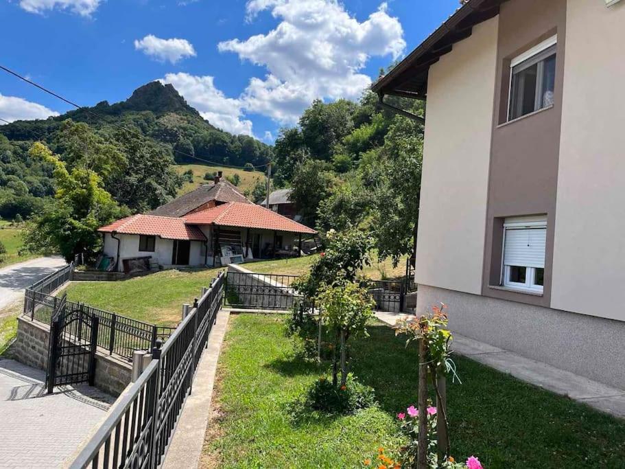 une maison avec une clôture devant une cour dans l'établissement Rudnička oaza mira, kuća u podnožju Ostrvice, à Gornji Milanovac
