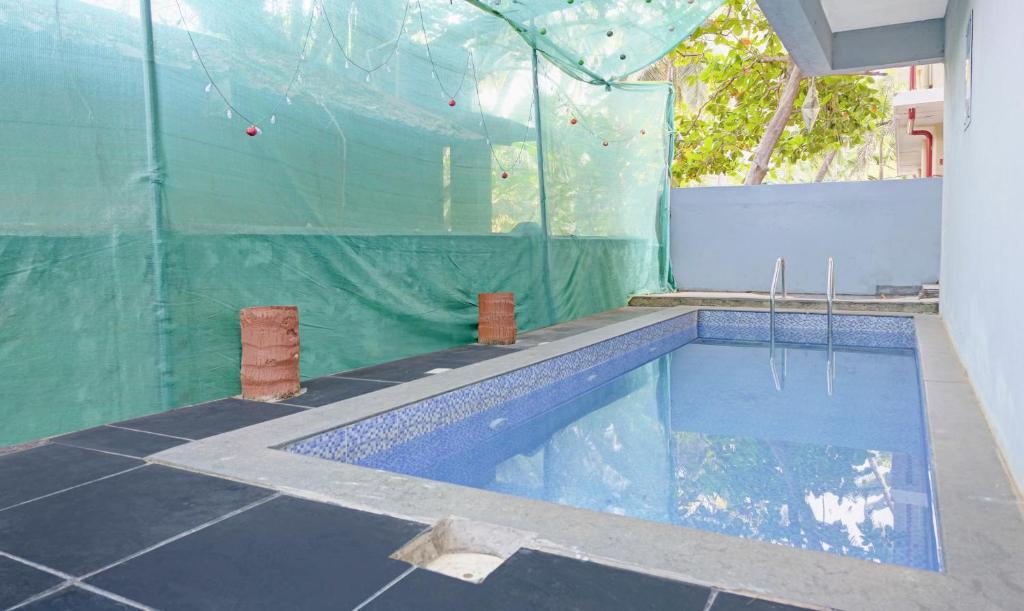 a swimming pool in a building with a plastic wall at Itsy By Treebo - Raj Resort, Calangute in Calangute