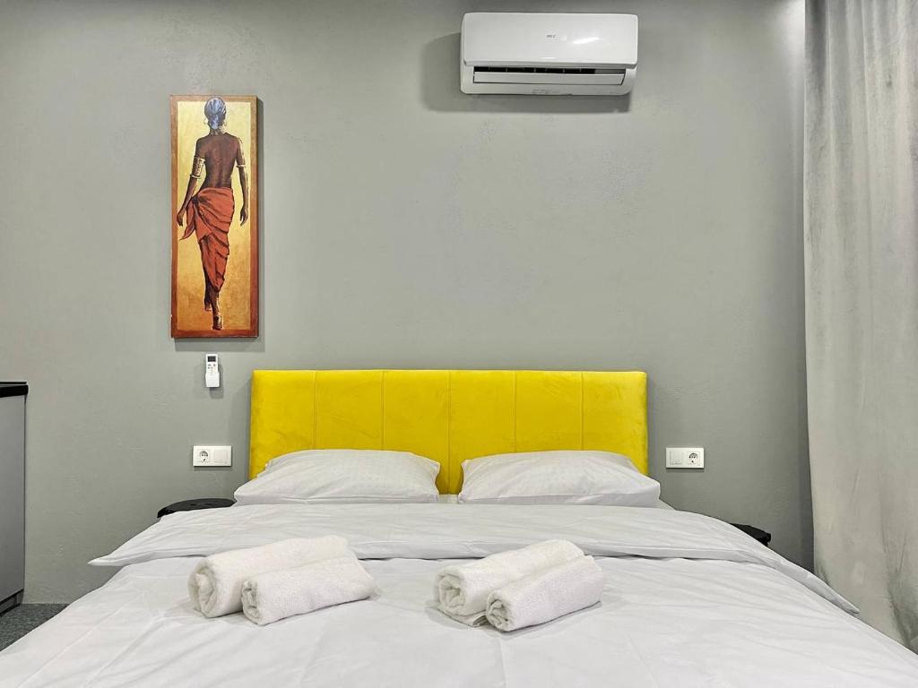 een slaapkamer met een wit bed en 2 handdoeken bij Апартаменти ТЦ Україна м. Університет in Kiev