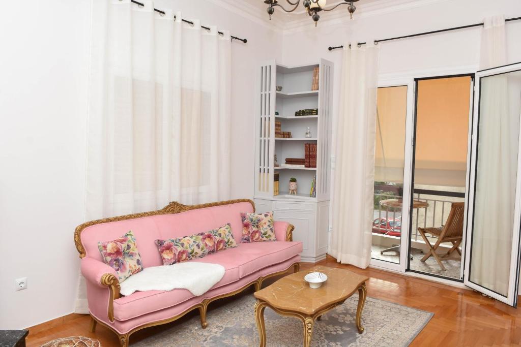 een woonkamer met een roze bank en een tafel bij Ellis house in Agrinion
