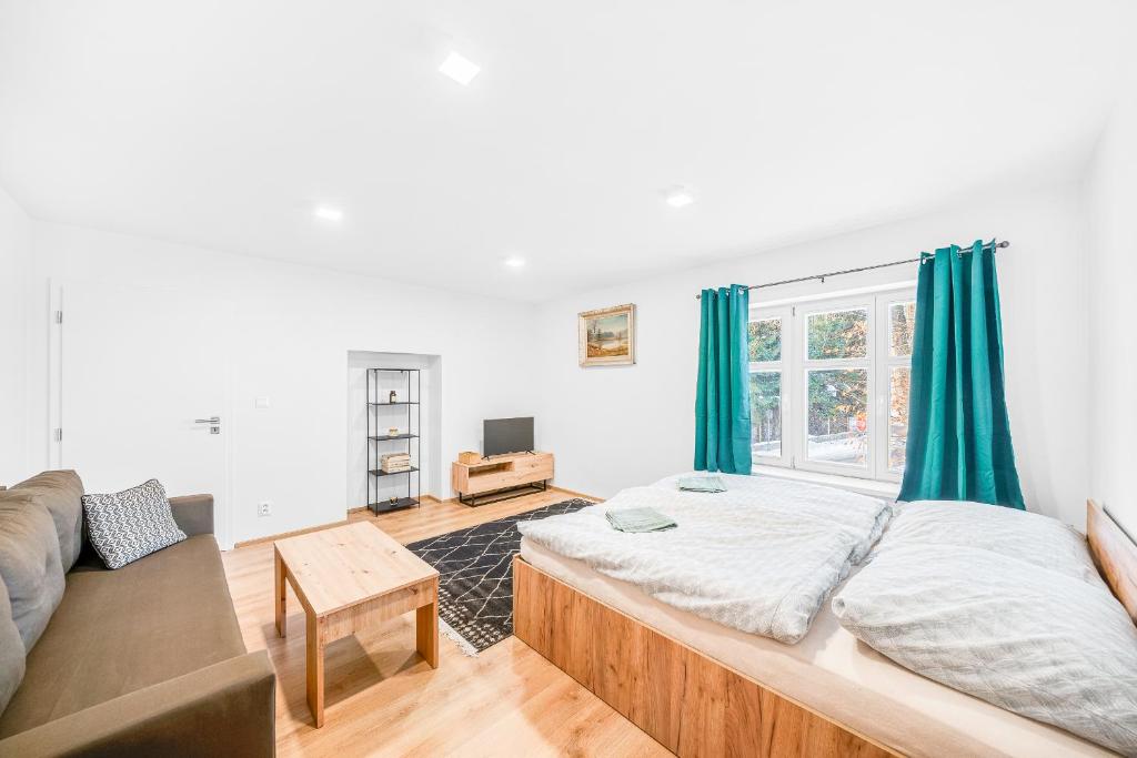 a bedroom with a large bed and a couch at Apartmán Barula in Kašperské Hory