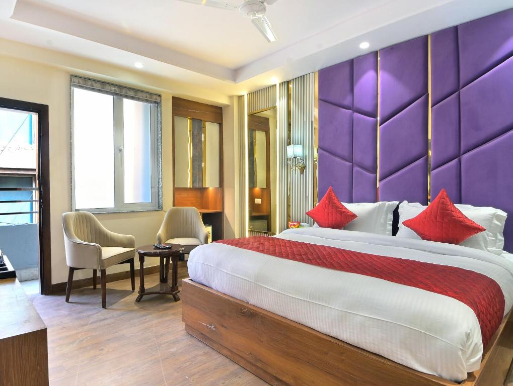 sypialnia z dużym łóżkiem i fioletową ścianą w obiekcie The Saina International - New Delhi - Paharganj w Nowym Delhi