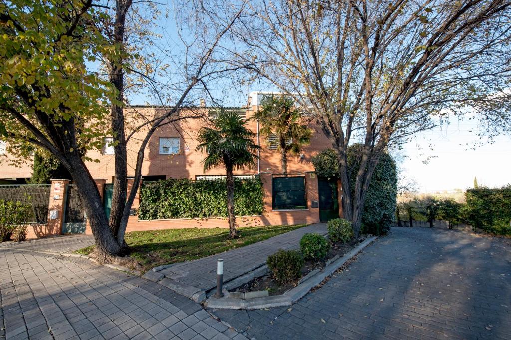 un edificio con árboles frente a una calle en Habitaciones Privadas en mi acogedor Chalet - Private rooms en Madrid