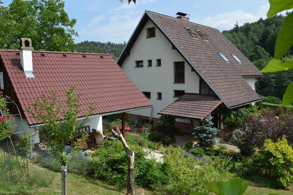 Biały dom z czerwonymi dachami i ogrodem w obiekcie Apartmány Český Ráj w mieście Turnov